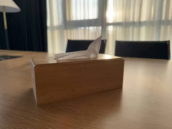 Gündüz güneşinde, modern bir ofisin toplantı odasında tahta peçete tutacağının içindeki peçeteler. Yüksek kalite fotoğraf