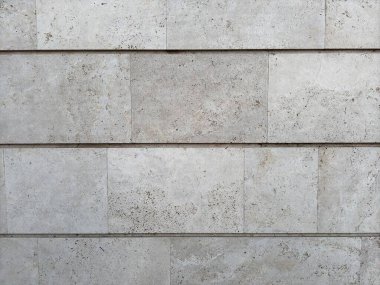 Arkaplan, kare ve dikdörtgen çizgilerle betondan yapılmış beyaz ve gri renkli eski bir duvar şeklinde. Yüksek kalite fotoğraf