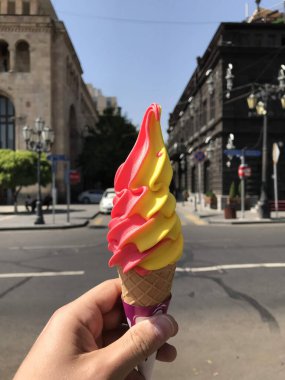 Yazın şehir merkezinde dalga şeklinde iki farklı çeşnili dondurma külahında dondurma. Yüksek kalite fotoğraf