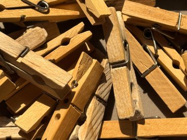 Çamaşır iğneleri bej renkli ahşap ve plastik renkli mandallar yakın mesafeden alınmış güneş ışınlarının altında gümüş metal yaylarla birlikte duruyor. Yüksek kalite fotoğraf