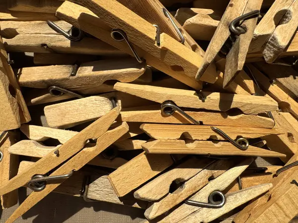Çamaşır iğneleri bej renkli ahşap ve plastik renkli mandallar yakın mesafeden alınmış güneş ışınlarının altında gümüş metal yaylarla birlikte duruyor. Yüksek kalite fotoğraf