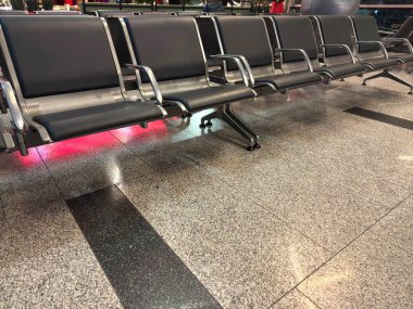 Havaalanı koltukları mavi ve boş, gümüş kolluklar ve kırmızı ışıklarla dolu. Yüksek kalite fotoğraf