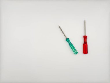 Plastik saplı dört renkli tornavida ortada mavi, yeşil, beyaz arka plan manzaralı. Yüksek kalite fotoğraf