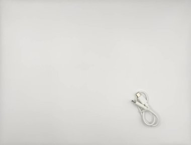 Beyaz kablo beyaz bir arkaplanda uzanıyor ve sağ alttaki kablolar için kauçuk bir bant bağlı. Yüksek kalite fotoğraf