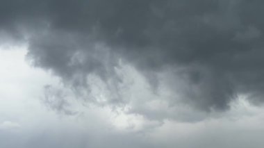 Siyah gri bulutlar şehrin üzerinde yavaşça hareket eder ve üzerine yağmur yağdırır. Yüksek kalite 4k görüntü
