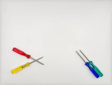 Plastik saplı dört renkli tornavida beyaz arka planda mavi, yeşil, sol ve sağ altta. Yüksek kalite fotoğraf