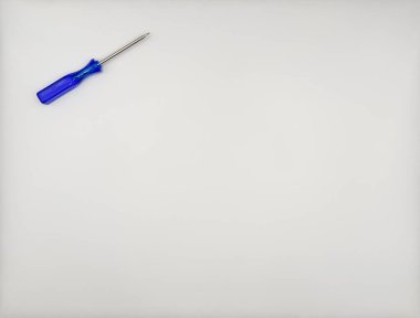 Beyaz arka plan manzaralı sol üst kısmında mavi plastik saplı renkli bir tornavida. Yüksek kalite fotoğraf