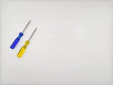 Plastik saplı iki renkli tornavida beyaz arka planda mavi sarı solda. Yüksek kalite fotoğraf