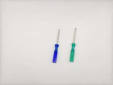 Plastik saplı iki renkli tornavida beyaz arka plan görünümünde mavi yeşil solda. Yüksek kalite fotoğraf