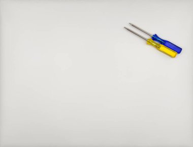 Plastik saplı iki renkli tornavida, beyaz arka plan manzarasında mavi sarı kapaklı. Yüksek kalite fotoğraf