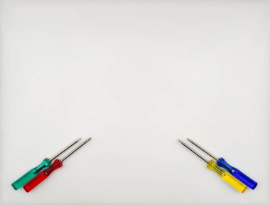 Plastik saplı dört renkli tornavida mavi yeşil sarı sol alttan beyaz arka plan manzaralı. Yüksek kalite fotoğraf