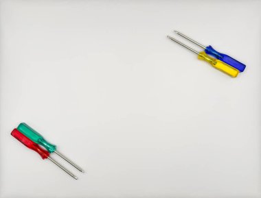 Plastik saplı dört renkli tornavida mavi yeşil sarı sol alttan beyaz arka plan manzaralı. Yüksek kalite fotoğraf