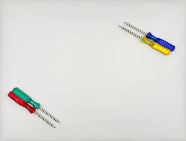 Plastik saplı dört renkli tornavida mavi yeşil sarı sol alttan beyaz arka plan manzaralı. Yüksek kalite fotoğraf