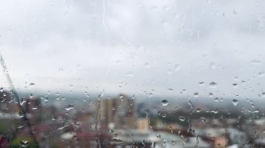 Günbatımında şehir manzaralı pencereye yağmur damlaları konacak. Makro kameralar olmadan yüksek kalitede. Yüksek kalite 4k görüntü