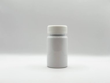 Kapağı kapalı beyaz ilaç kavanozu beyaz arka planda, görüntünün önünde duruyor. Yüksek kalite fotoğraf