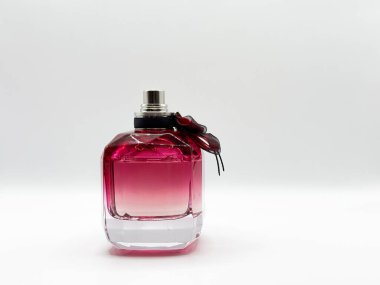 Mor renkli cam bir parfüm şişesi ve beyaz arka plan manzaralı bir fiyonk. Yüksek kalite fotoğraf