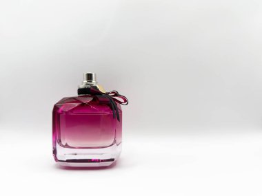 Cam bir parfüm şişesi mor renkli, kapağında beyaz arka planda bir fiyonk var. Yüksek kalite fotoğraf