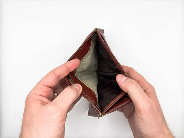 Zavallı adam, eski püskü deri bir cüzdan tutuyor. Parası yok, kredi kartları ve nakit para için açık pozisyonda. Görüntünün merkezindeki beyaz arka planda. Yüksek kalite fotoğraf