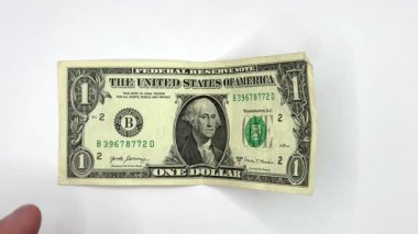 Erkek beyaz eller 1 dolarlık bir banknot alır ve 100 dolarlık bir deste verir. Bu da gösteriyor ki, para kazanmak için önce beyaz arka plandaki bir objeden vergi ödemeniz gerekir.