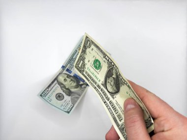 Beyaz erkek beyaz eller, beyaz arka planda 100 dolara karşılık 1 dolarlık banknot tutuyor. Yüksek kalite fotoğraf