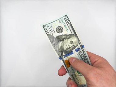 Beyaz erkek beyaz el, beyaz arka planda polise rüşvet vermek için 100 dolar tutuyor. Yüksek kalite fotoğraf