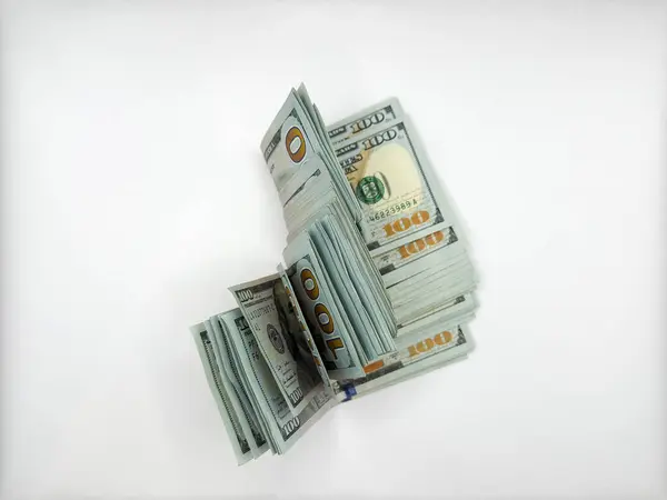 Bir yığın dolar, görüntünün merkezinde katlanmış düz bir zeminde 100 dolar değerinde beyaz bir zeminde yatıyor. Yüksek kalite fotoğraf