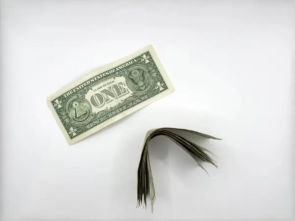 Eski tarz bir dolar beyaz bir arka planda yatıyor ve yanında da yığınla dolar yatıyor. Yüksek kalite fotoğraf