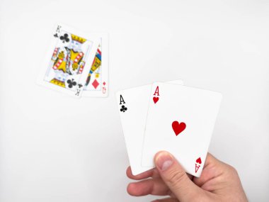 Beyaz erkek eli, beyaz arka planda iki as olan beyaz plastik poker kartları gösteriyor. Yüksek kalite fotoğraf
