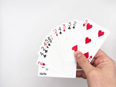 Beyaz erkek eli beyaz arka planda görüntünün ortasında beyaz plastik poker kartları gösteriyor. Yüksek kalite fotoğraf
