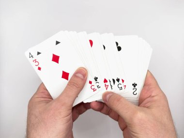 Beyaz erkek eli beyaz arka planda görüntünün ortasında beyaz plastik poker kartları gösteriyor. Yüksek kalite fotoğraf
