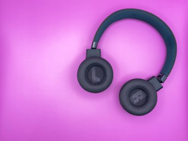 L ve R harfli yumuşak kulaklıklı yeşil kulaklıklar ve pembe arka planda görüntünün sağ tarafında yumuşak bir saç bandı var. Yüksek kalite fotoğraf