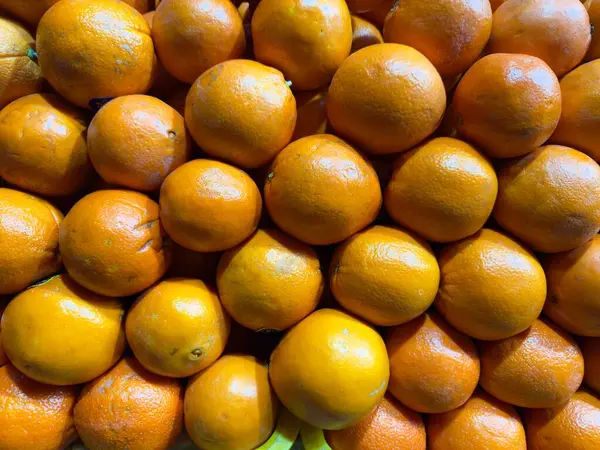 Taze portakallar parlak turuncu renkler suni ışık olmayan doğal ışıkta tezgahta duruyor. Yüksek kalite fotoğraf