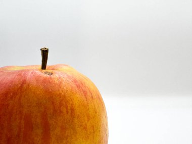 Taze sulu kırmızı elma, üst kısmında yapışkan, sol arka planında siyah nokta, makro ön görünümde. Yüksek kalite fotoğraf