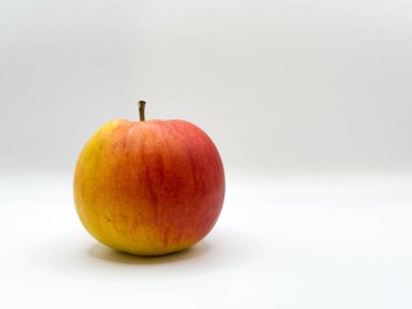 Sarı noktalı taze kırmızı elma ve beyaz arkaplanda sol ön planda kalıyor. Yüksek kalite fotoğraf