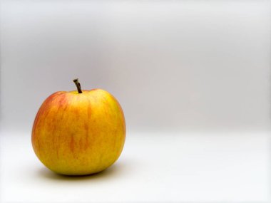 Taze, sulu, sarı bir elma. Arkaplanda beyaz bir zemin var. Görüntüde solda. Yüksek kalite fotoğraf