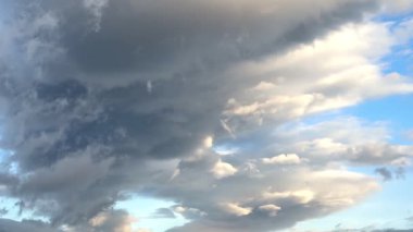 Mavi gökyüzüne karşı beyaz ve gri bulutlar yağmurdan önce ağır çekimde uzanıyordu. Yüksek kalite 4k görüntü
