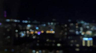 Gece şehrinin sarı, mavi ve kırmızı ışıklarının uğultusu yavaş çekimde yükseliyor. Yüksek kalite 4k görüntü