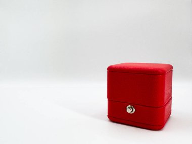 Görüntünün sağ arka planında kırmızı, dikdörtgen, deri bir alyans kutusu. Yüksek kalite fotoğraf