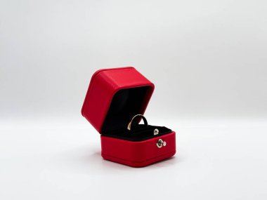 Elmassız altın alyans kırmızı alyans kutusunda. Açık pozisyondaki dikdörtgen deri merkezde. Resmin önünde. Yüksek kalite fotoğraf