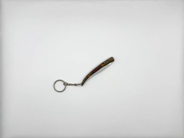 Anahtarlık halkalı küçük metal bıçak ve görüntünün ortasında çok renkli bir kol kapalı bir arkaplanda beyaz bir zemin üzerinde. Yüksek kalite fotoğraf