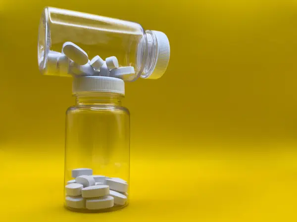 İlaç, tablet, kapsül ve sarı arka planda şişe çeşitleri. Düz yatıyordu. - Evet. Yüksek kalite fotoğraf