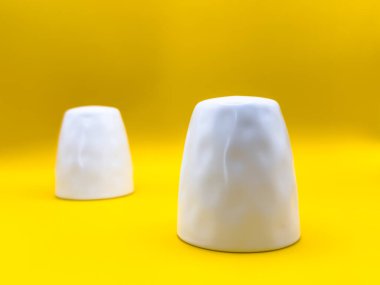 Beyaz seramik tuz ve biber karıştırıcılar görüntünün ortasında sarı bir zemin üzerinde, üst manzara. Yüksek kalite fotoğraf