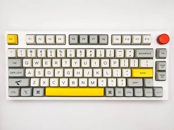 Aksanlı sarı düğmeli beyaz klavye ve uzaktan kumanda için kırmızı düğme. Üst görünümü beyaz arkaplanlı. Yüksek kalite fotoğraf