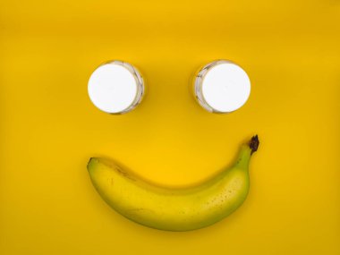 Görüntünün ortasında bir muz ve iki ilaç şişesinden yapılmış gülen surat. Yüksek kalite fotoğraf