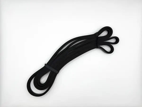 Siyah silikon genişletici, evde her türlü kas için bağımsız olarak 20 kilogram ve görüntünün merkezindeki beyaz arka planda çeşitli egzersizler için kullanılıyor. Yüksek kalite fotoğraf