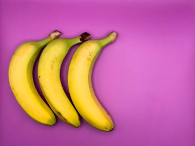 Mor arka planda üç sarı muz. Yüksek kalite fotoğraf