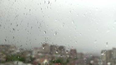 Pencere camına yağmur damlaları, arka plandaki binalar. Yüksek kalite 4k görüntü