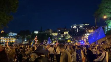 Tiflis, Gürcistan - 9 Mayıs 2025: Tiflis sokaklarında düzenlenen gece gösterisinde AB ve Gürcistan bayrakları taşıyan kalabalık Avrupa entegrasyonunu tutkuyla destekliyor. Yüksek kalite 4k görüntü