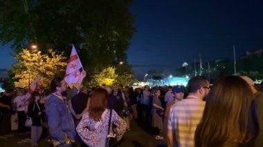 Tiflis, Gürcistan - 9 Mayıs 2025: Tiflis sokaklarında düzenlenen gece gösterisinde AB ve Gürcistan bayrakları taşıyan kalabalık Avrupa entegrasyonunu tutkuyla destekliyor. Yüksek kalite 4k görüntü