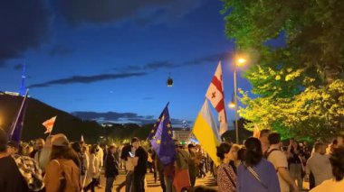 Tiflis, Gürcistan - 9 Mayıs 2025: Tiflis sokaklarında düzenlenen gece gösterisinde AB ve Gürcistan bayrakları taşıyan kalabalık Avrupa entegrasyonunu tutkuyla destekliyor. Yüksek kalite 4k görüntü